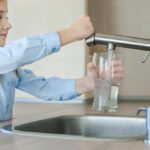 Little,Girl,Opens,A,Water,Tap,With,Her,Hand,Holding