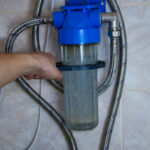 A,Man,Attaches,A,Home,Water,Softener,To,The,Wall